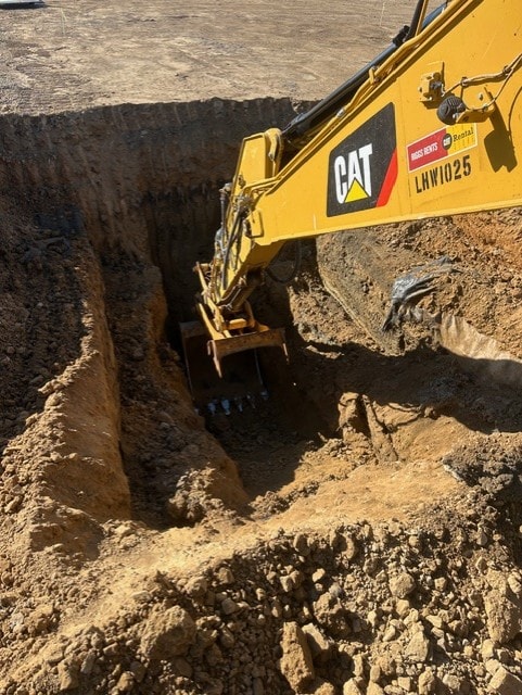 CAT excavator in deep trench